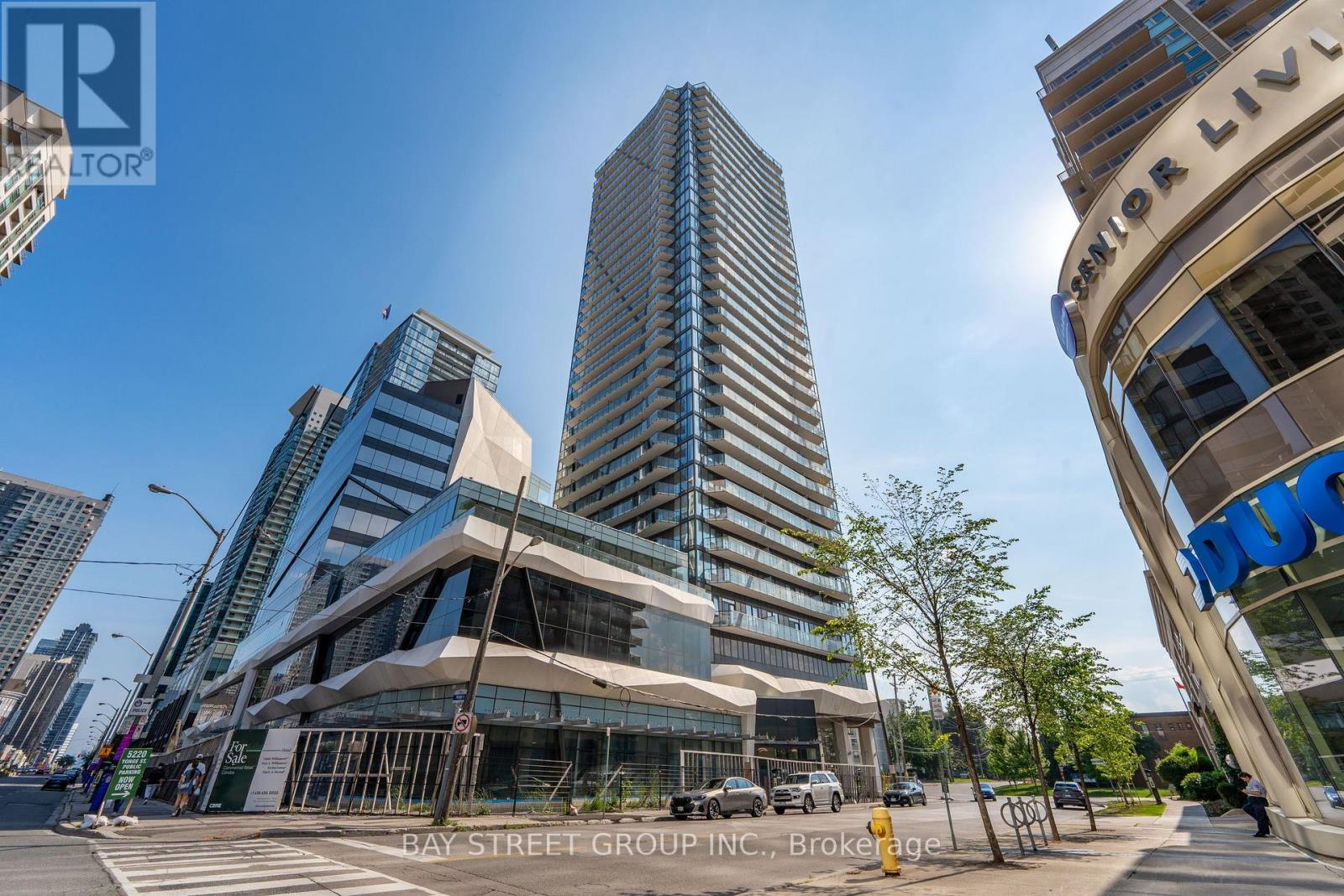 A modern building with a glass facade stands tall in a cityscape.