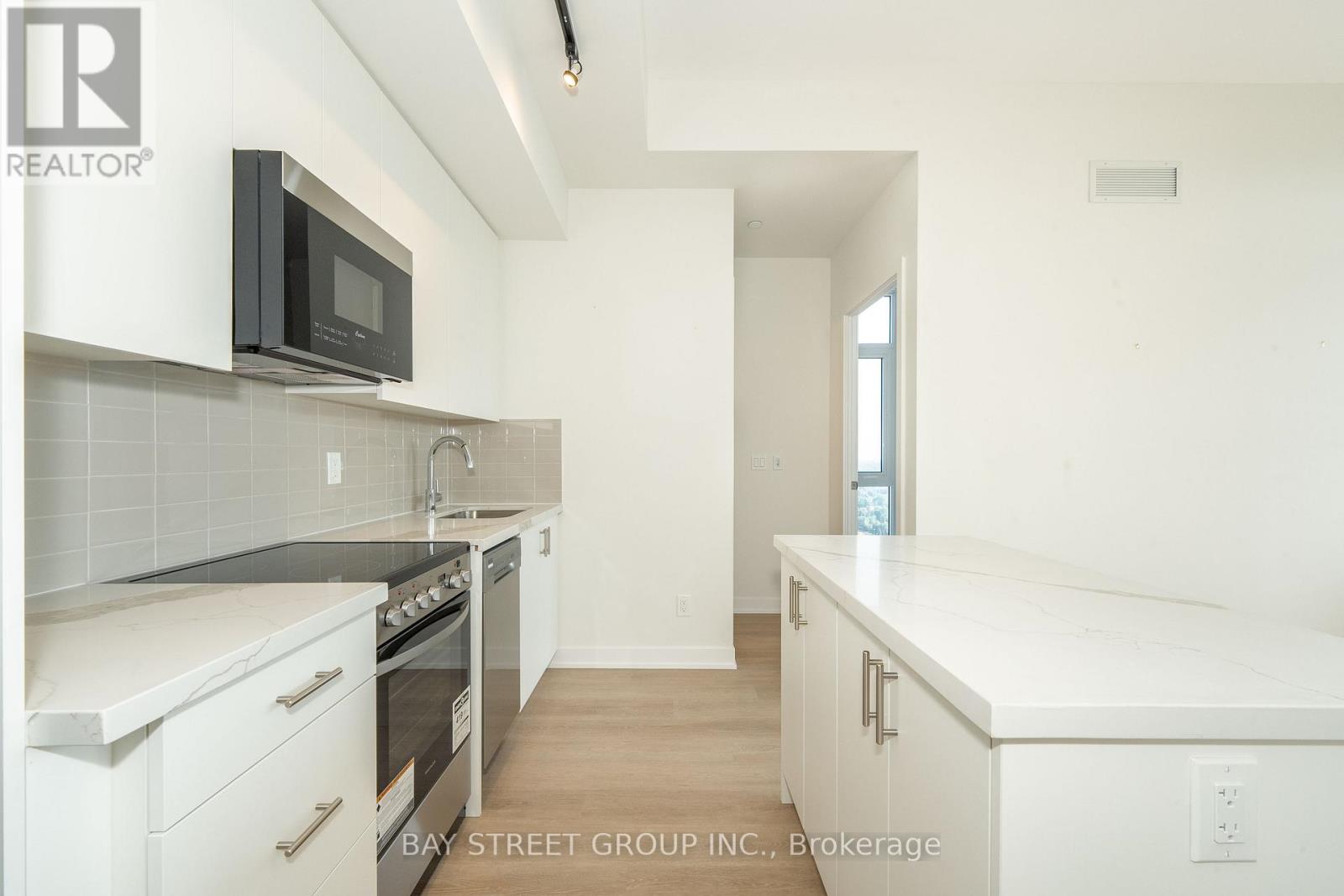 A kitchen with white cabinets and appliances is on the market.