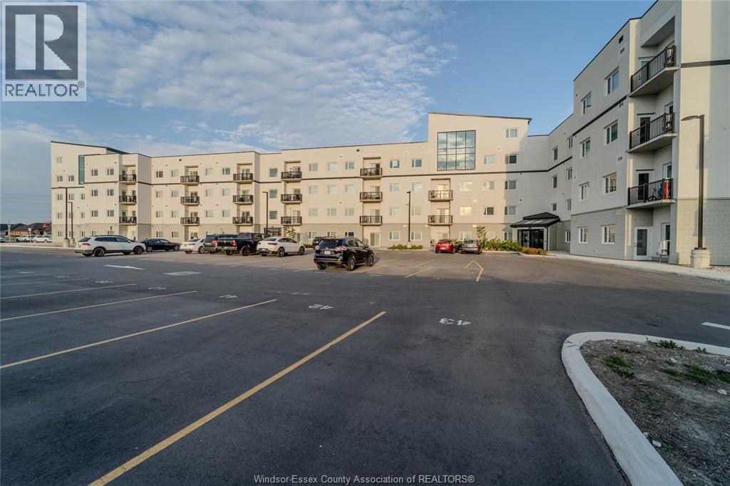 A parking lot in front of a multi-story apartment building.