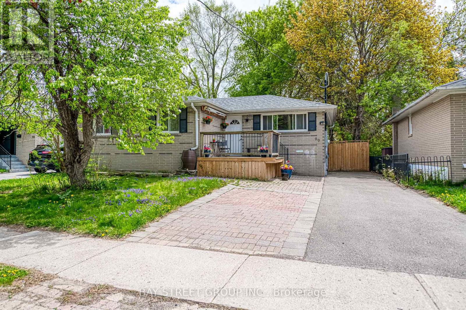 A house with a driveway and a tree in front.