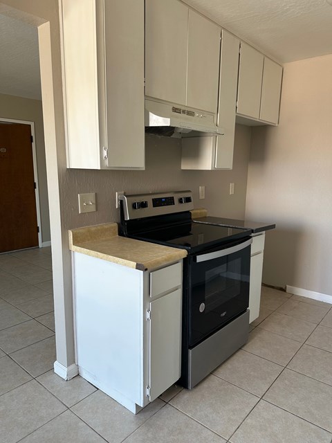 A kitchen with a white oven and black stove top.