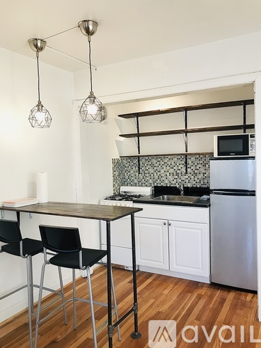 A kitchen with a table and chairs and a refrigerator.