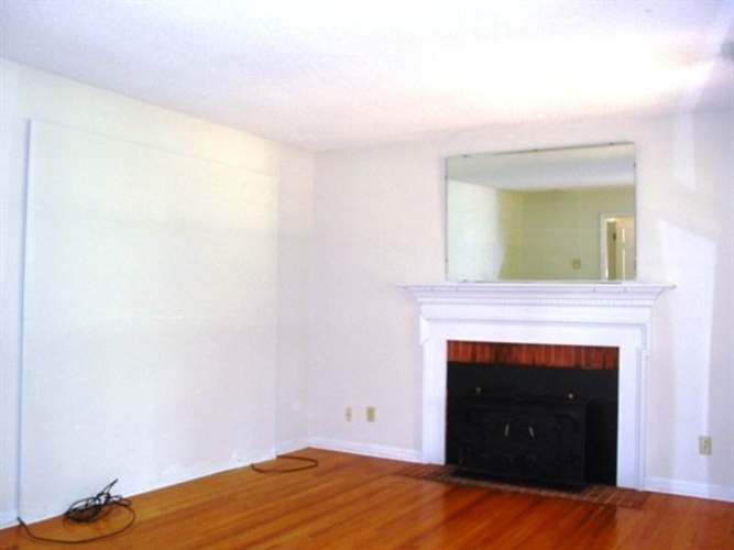 A room with a fireplace and a mirror on the wall.
