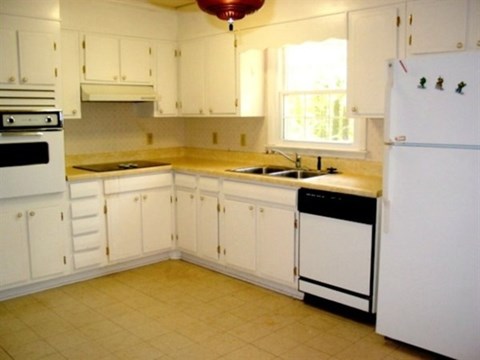 A kitchen with white cabinets and appliances.