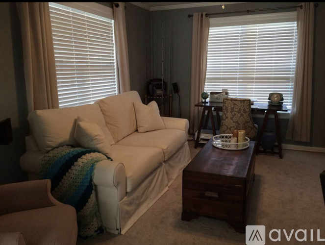 A living room with a white couch and a wooden coffee table.