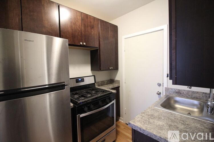 A kitchen with a stainless steel refrigerator and a stove top oven.