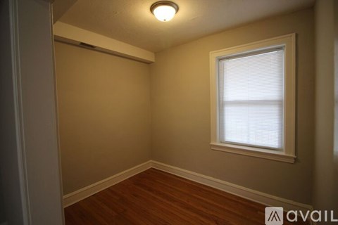 A room with a window and wooden floors.