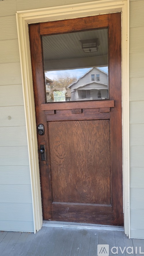A brown door with a glass window in the middle.