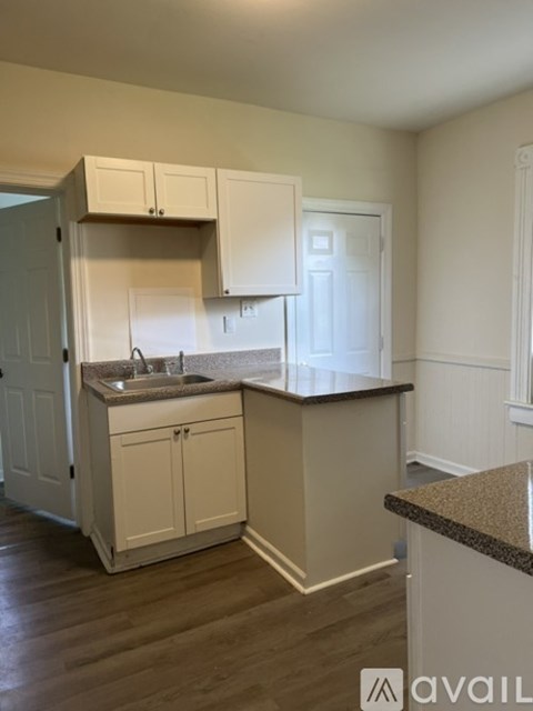 A kitchen with white cabinets and a granite countertop.