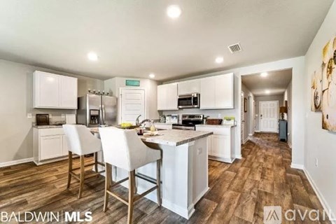A kitchen with white cabinets and a wooden floor.