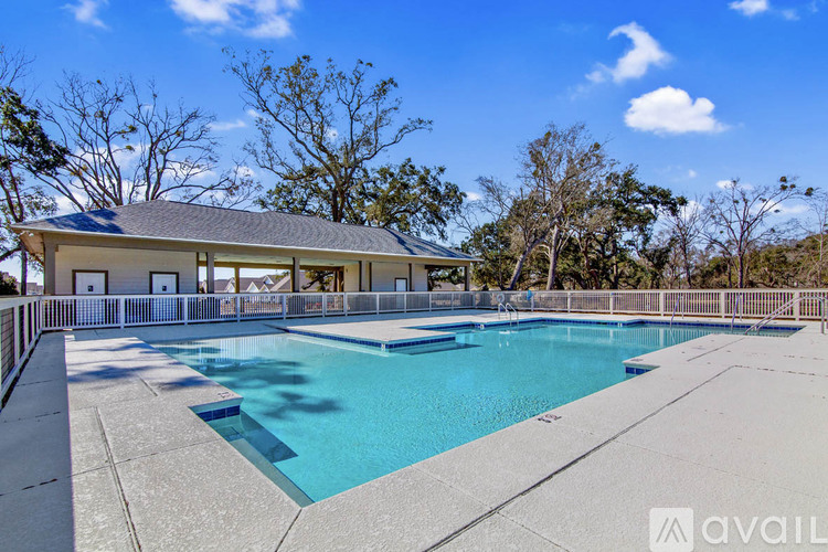 A large outdoor swimming pool with a house in the background.
