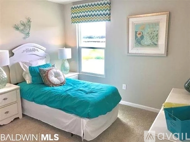 A bedroom with a white bed and a blue comforter.