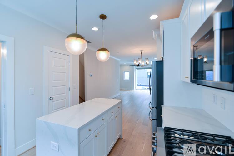 A modern kitchen with a white countertop and a black stove.