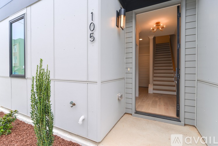 A modern house numbered 105 with a small garden in front.