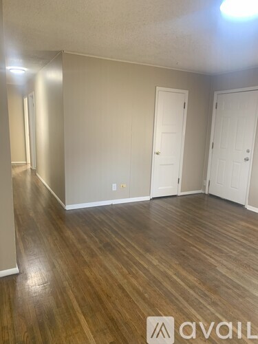 A room with wooden flooring and two white doors.