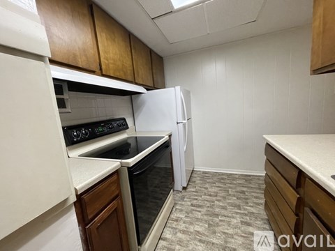 A kitchen with a white refrigerator and a black stove top oven.