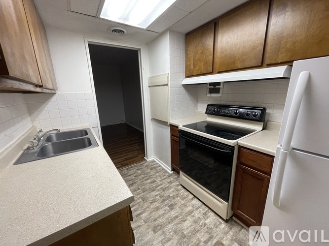 A kitchen with a sink, oven, and refrigerator.