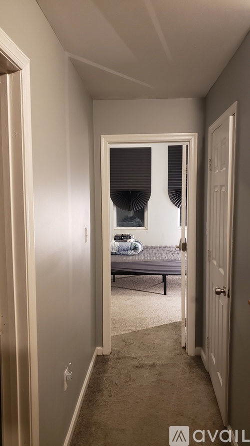 A bedroom with a bed and a window with blinds.