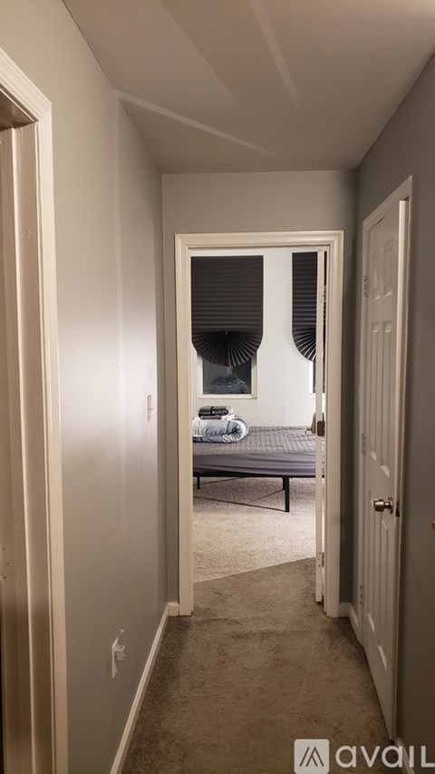 A bedroom with a bed and a window with blinds.