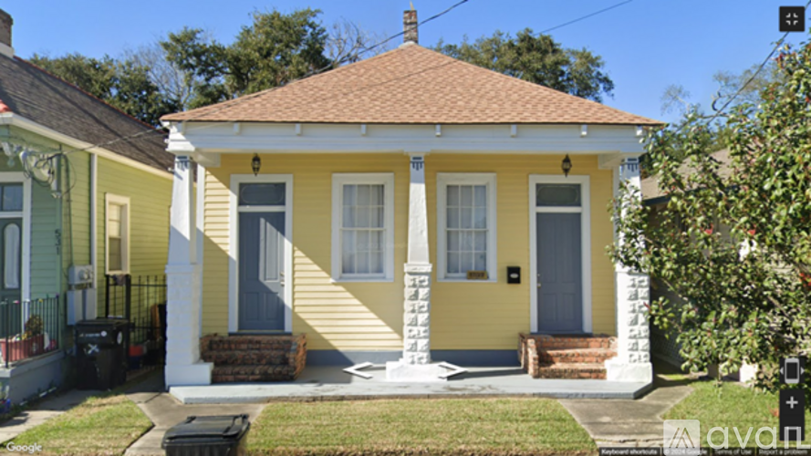A yellow house with a porch and a grey door.