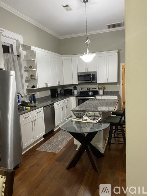 A kitchen with a glass table and a refrigerator.