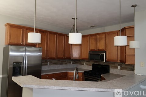 A kitchen with wooden cabinets and a stainless steel refrigerator.