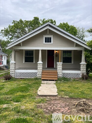 A small house with a porch and a red door.