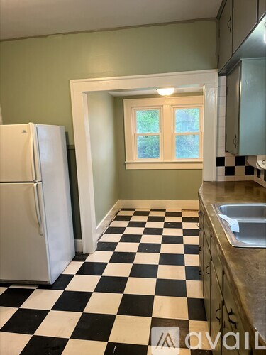 A kitchen with a checkered floor and a white fridge.