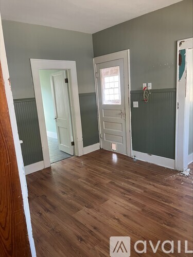 A room with wooden floors and two white doors.