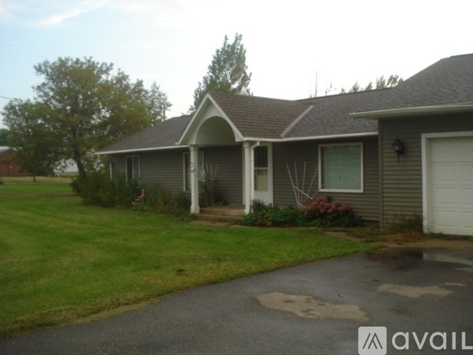 A house with a grey roof and a white garage door.