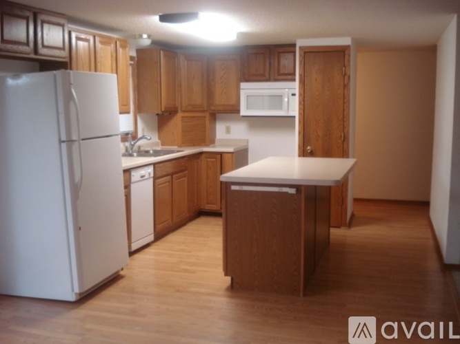 A kitchen with wooden cabinets and a white refrigerator.