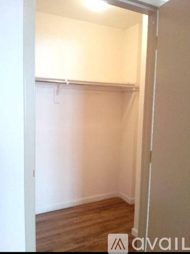 A bare room with a wooden floor and white walls.