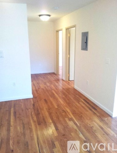 A hallway with wood flooring and white walls.