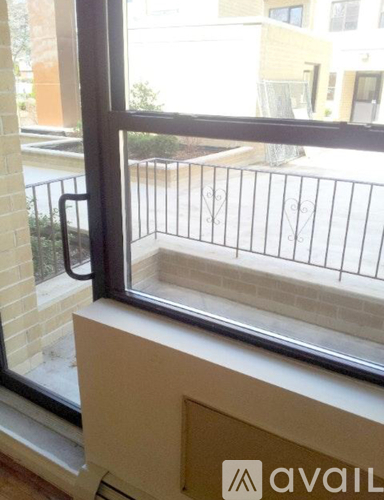 A window with a view of a balcony and buildings outside.