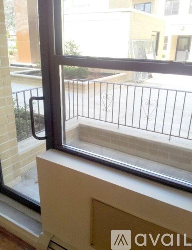 A window with a view of a balcony and buildings outside.