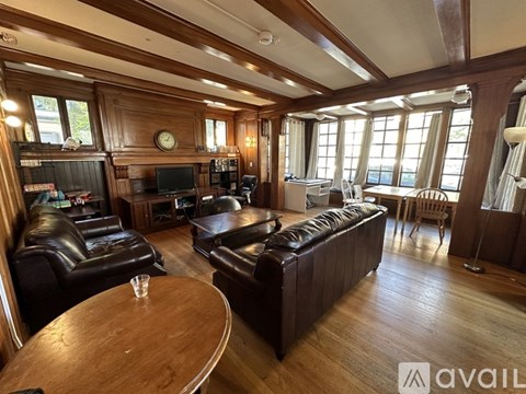A living room with brown leather furniture and a wooden table.