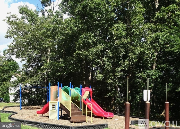 A playground with a red slide and a green slide.
