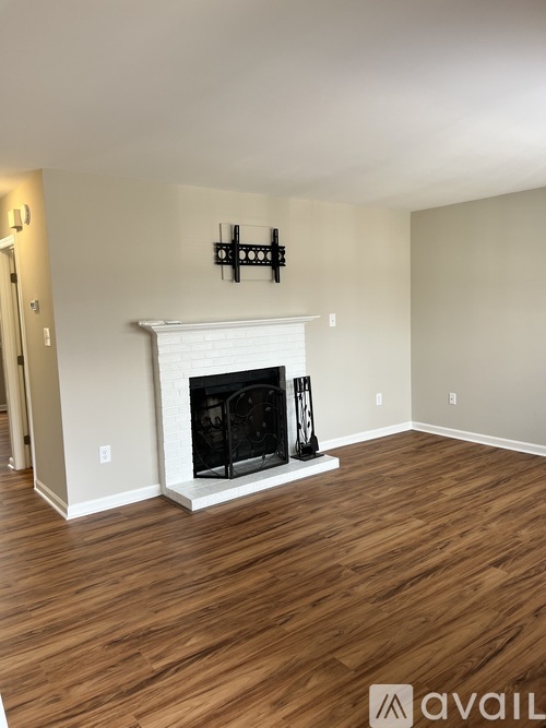 A living room with a fireplace and wooden floors.