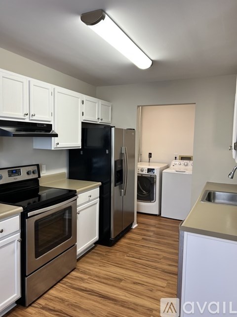 A kitchen with white cabinets and a black stove top oven.
