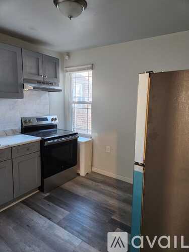 A kitchen with a stove top oven and a refrigerator.