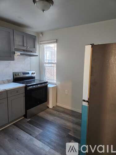 A kitchen with a stove top oven and a refrigerator.