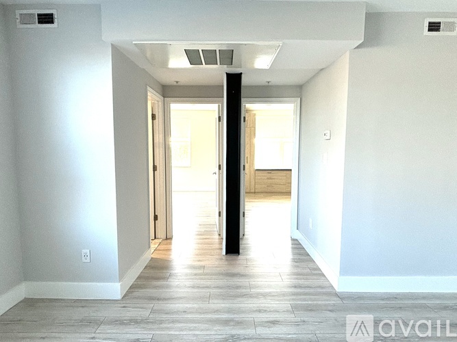 A spacious room with a doorway leading to another room.