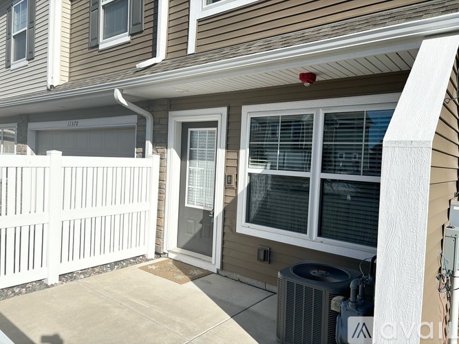 A house with a white fence and a window with blinds.