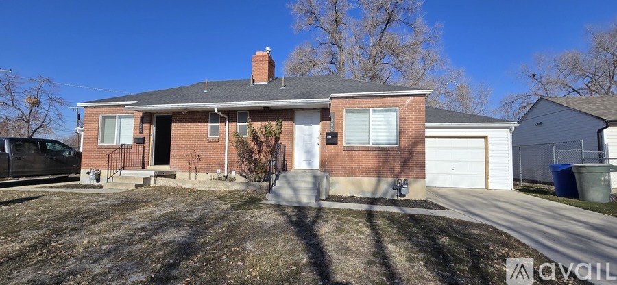 A house with a brick facade and a white garage door is for sale.