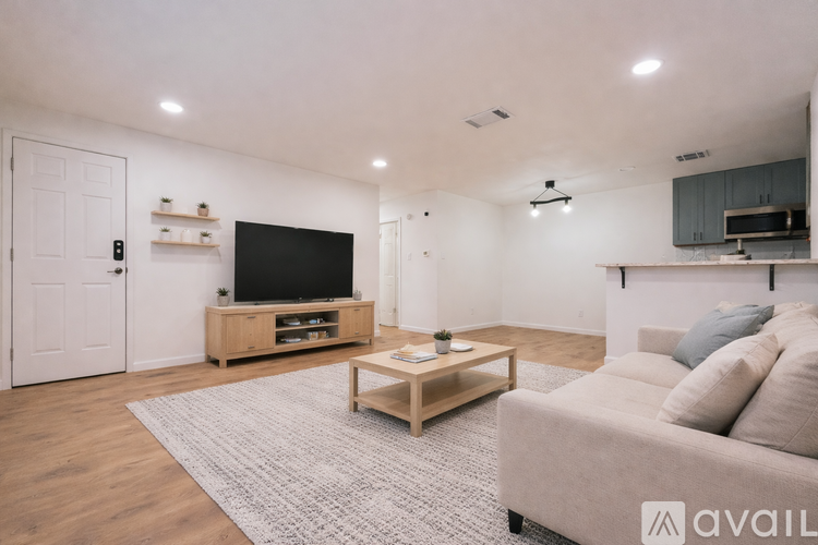 A living room with a couch, a coffee table, and a television.