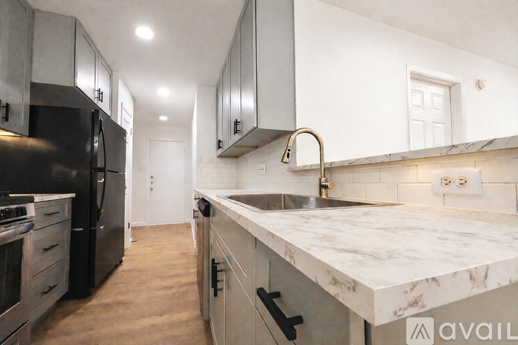 A kitchen with a marble countertop and stainless steel appliances.