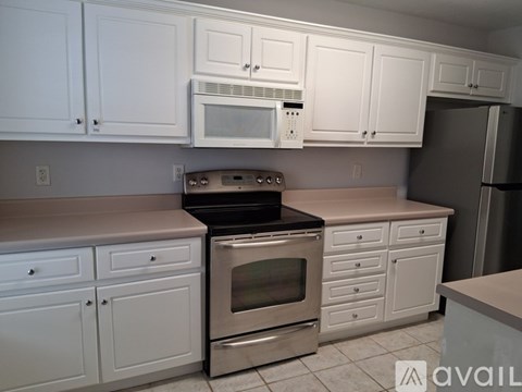 A kitchen with white cabinets and stainless steel appliances.