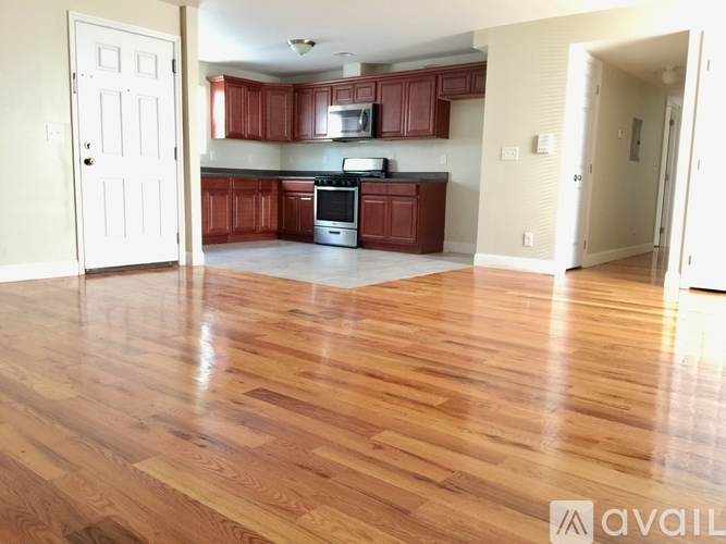 A kitchen with wooden floors and red cabinets.