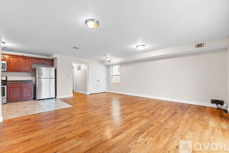 A kitchen with red cabinets and black appliances.