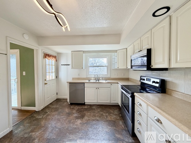 A kitchen with a black stove top oven and white cabinets.